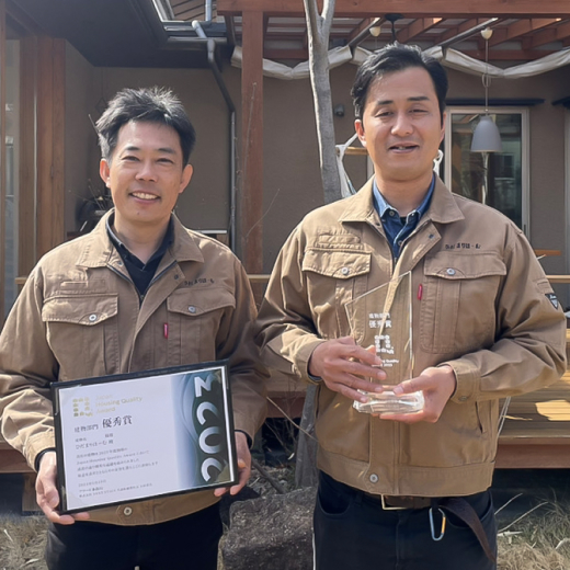 表彰状とトロフィーを手に微笑むひだまりほーむの男性2人